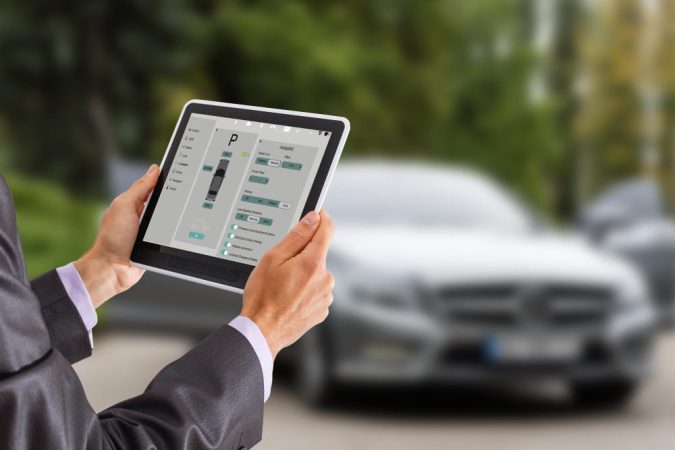 Gros plan sur une tablette affichant l'interface de contrôle Autopilot, utilisée pour illustrer une analyse financière de Tesla